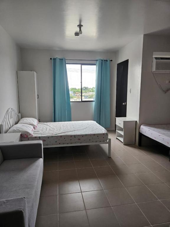 a bedroom with two beds and a window at Leina Life-Style Comfy Studio Balcony near Mactan Airport in Bankal