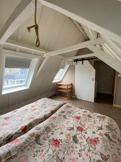 a bedroom with a bed with a floral bedspread at B & Buitenlust in Schagerbrug