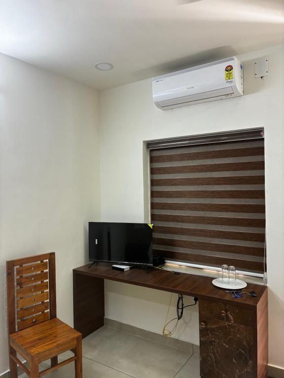 a room with a desk with a computer and a air conditioner at KOTTOOR LODGE Parakode in Adūr