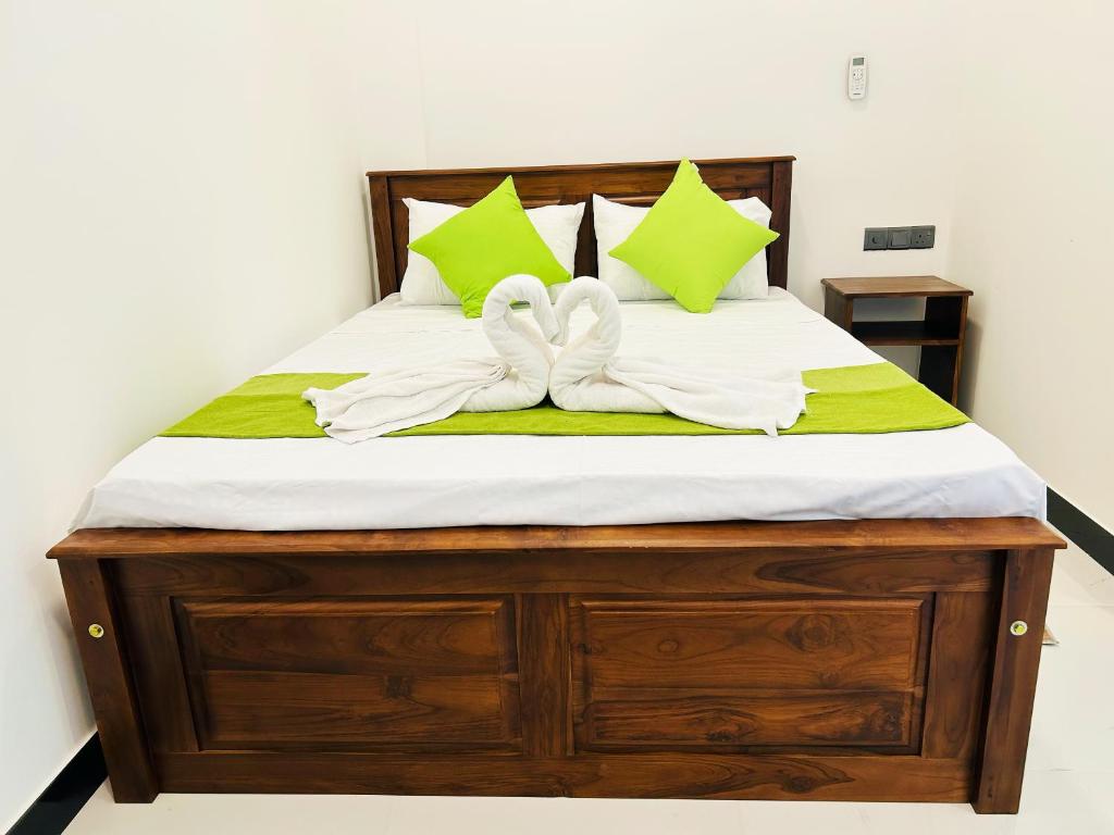 a bed with two white towels on top of it at Nushi Inn in Katunayaka