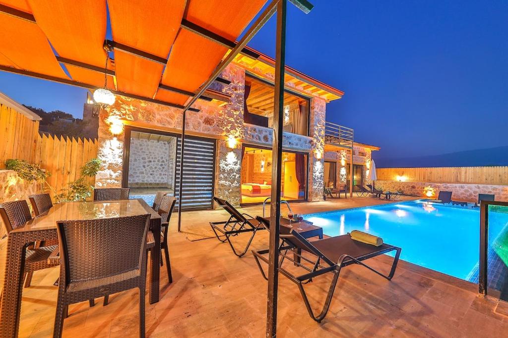 a house with a swimming pool and a table and chairs at Patara breeze in Kaş