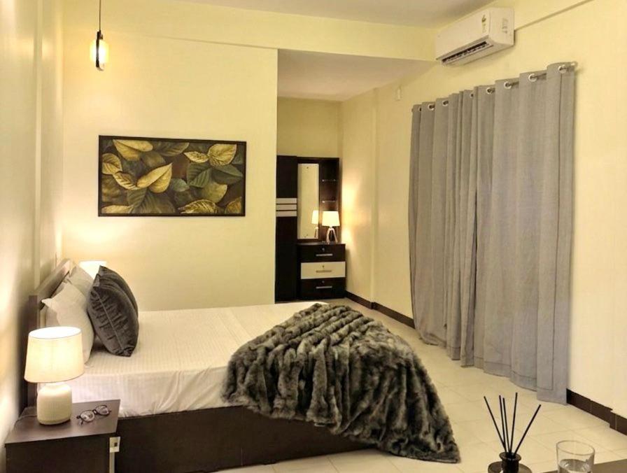 a bedroom with a bed with a blanket on it at Skylora Heights Inn in Kozhikode
