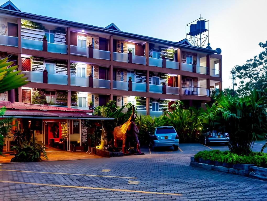 a building with a giraffe statue in front of it at African Tribe Hotel in Kampala