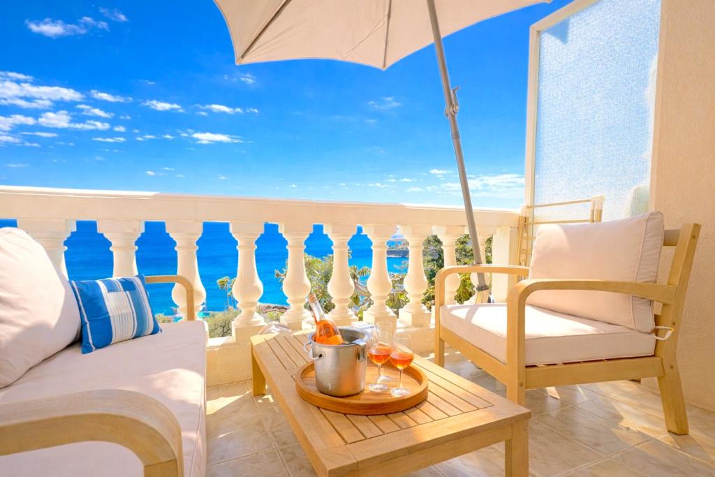 a balcony with a bed and a table with an umbrella at Vue mer & terrasse Studio calme parking St Raphaël in Saint-Raphaël
