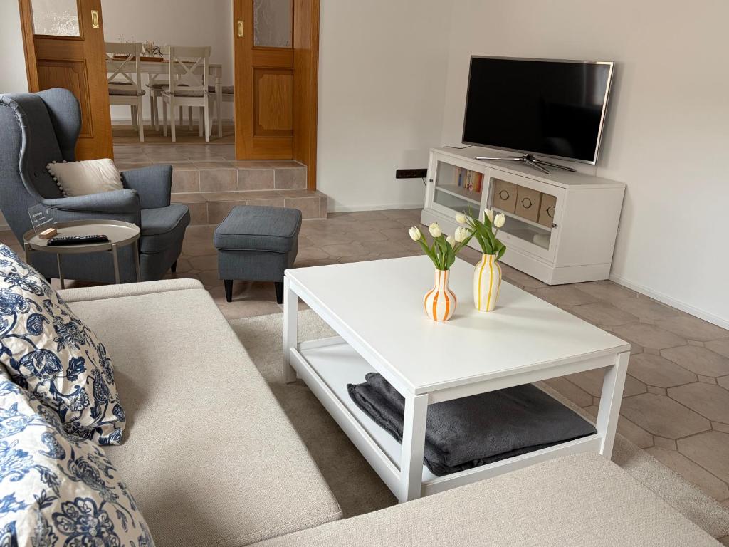 a living room with a tv and a white coffee table at Ferienwohnung Sensbachtal in Untersensbach