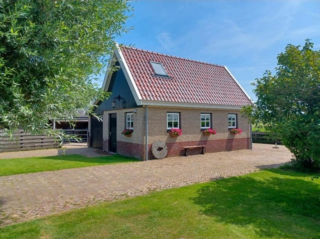 a house with a bench in front of it at 't Veldthuisje in Uitgeest