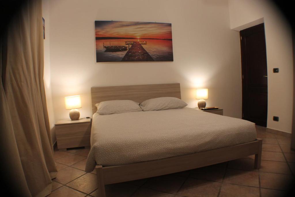 a bedroom with a bed and two lamps on tables at Camera confortevole tra Roma e Ostia in Acilia