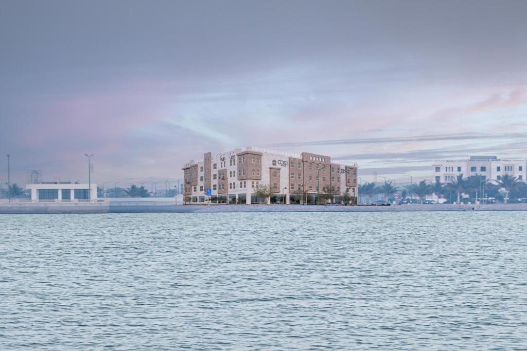 a building on the shore of a body of water at Corp Yanbu Hotel - B2 in Yanbu