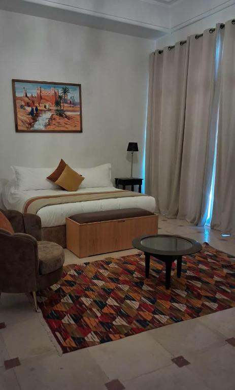 a bedroom with a bed and a table and a couch at Villa maryama in Marrakesh