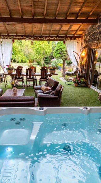 a hot tub in the middle of a yard at Cottage River & Spa in Saint-Ilpize