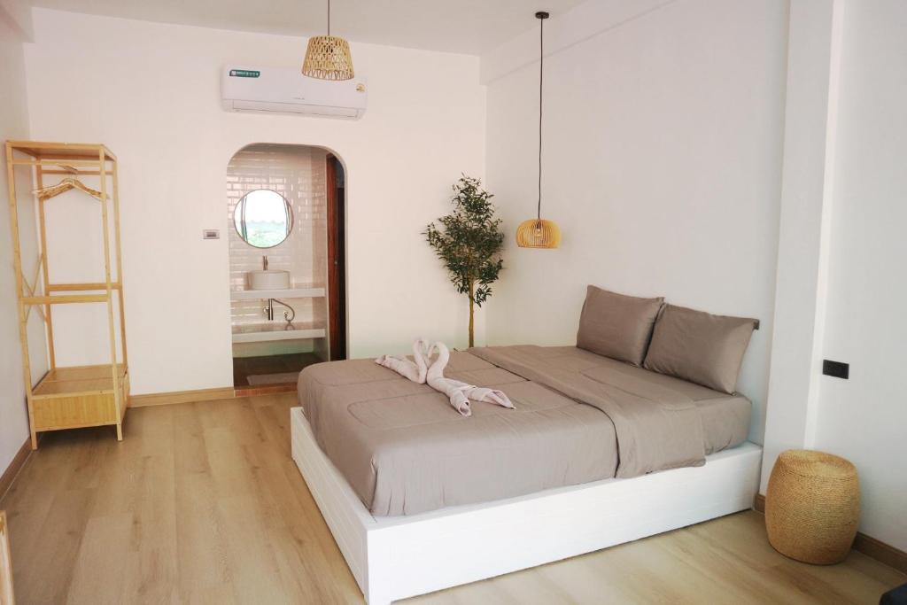 a bedroom with a bed in a white room at ชรัส รีสอร์ท เกาะล้าน in Ko Larn