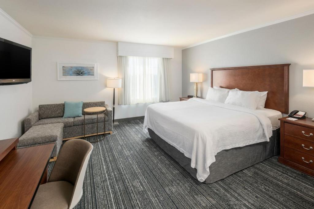 a hotel room with a large bed and a couch at TownePlace Suites by Marriott Tucson Williams Centre in Tucson