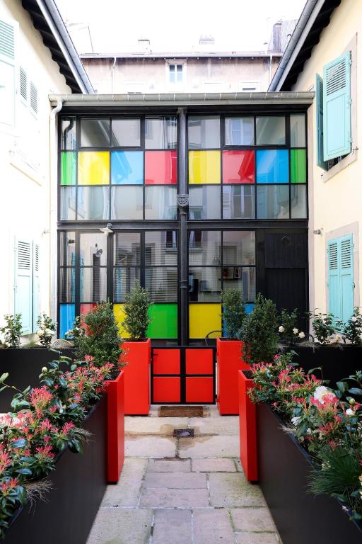 a building with colorful windows and plants in a courtyard at Le Quai Verrière in Belfort