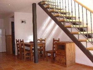 a dining room with a table and a staircase at Las Casitas de los Mata in Landete