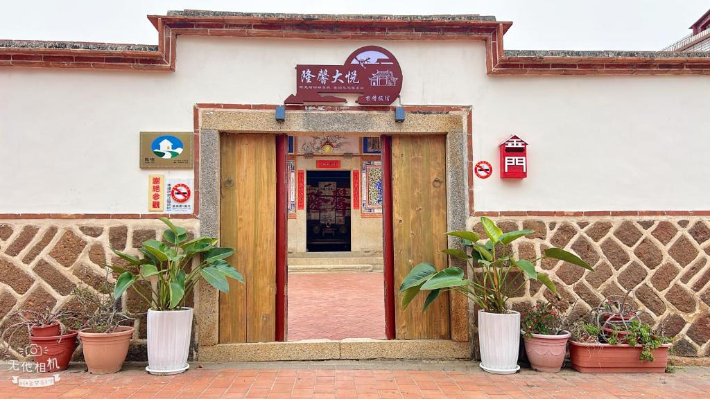 a door to a building with potted plants in front of it at 隆馨大悅古厝旅宿 in Jinhu