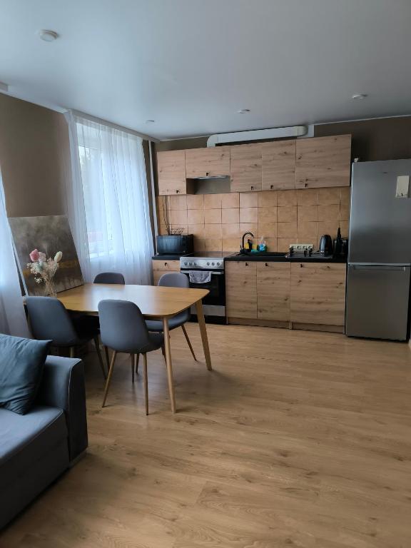 a kitchen with a table and a kitchen with a refrigerator at Apartment GLORIA in Narva-Jõesuu