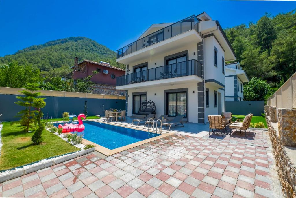 a villa with a swimming pool and a house at Villa Huzur in Fethiye