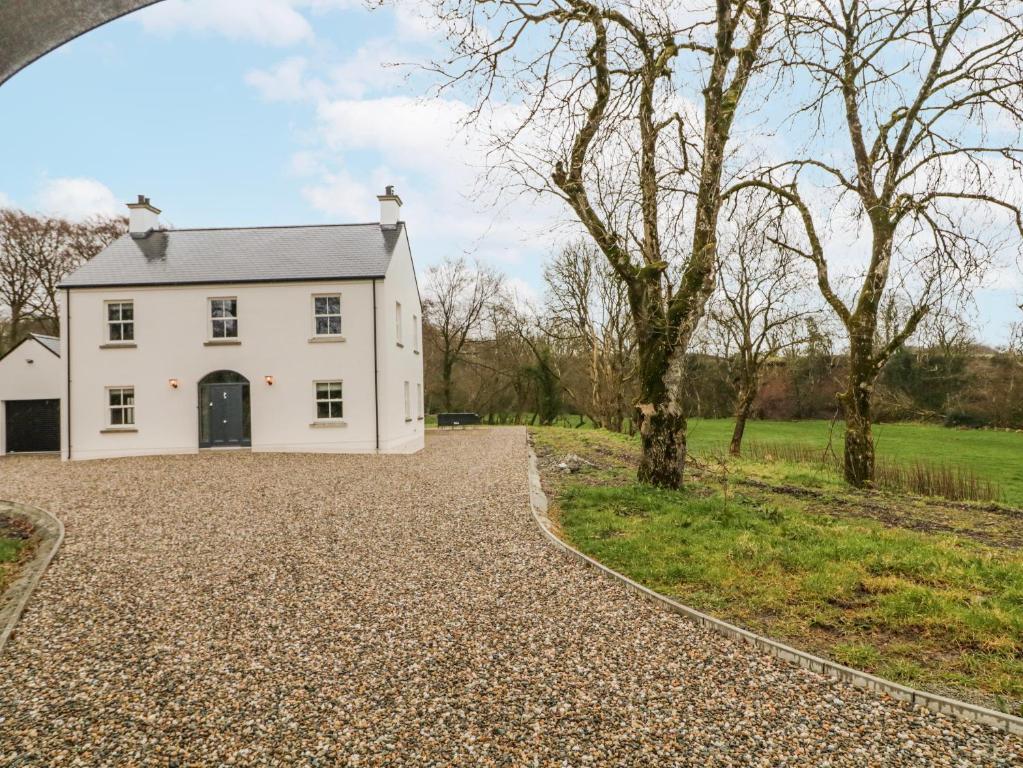 a white house with a gravel driveway at Cloneytrace Mines in Ballymena