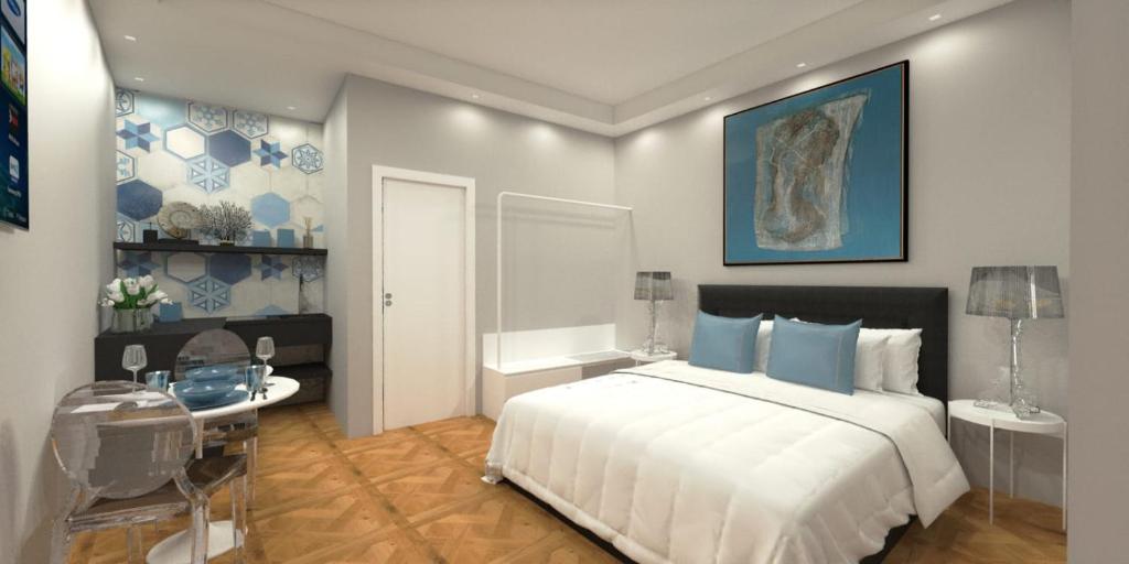a bedroom with a large white bed and a table at Suite Enea San Rocco in Sperlonga