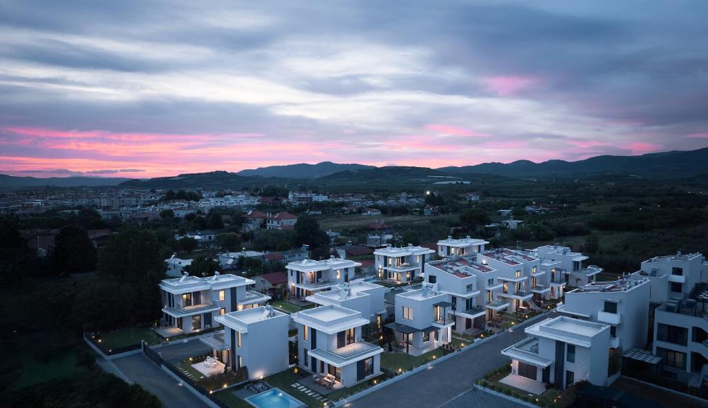 a group of white buildings in a city at sunset at Nefeli & Nefeli Luxury Residential Complexes in Ofrínion