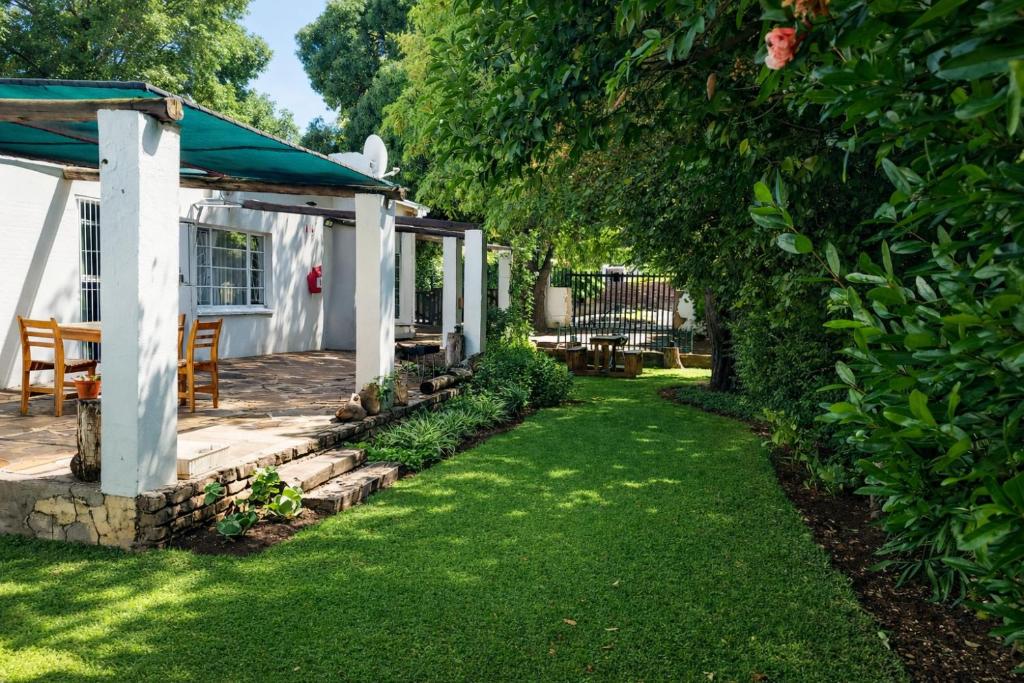 a garden with a table and chairs under a tree at 7 On Grey Guesthouse in Colesberg