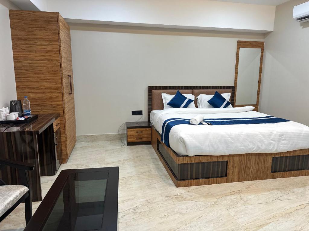 a bedroom with a large bed with blue pillows at Hotel Manjit Banquet in Fālākāta