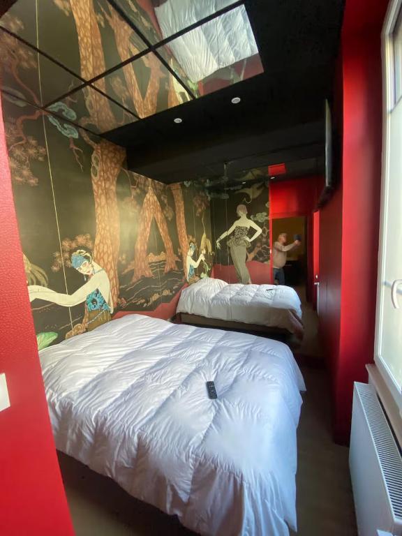 two beds in a room with a mural on the wall at Sweety Room in Chamalières