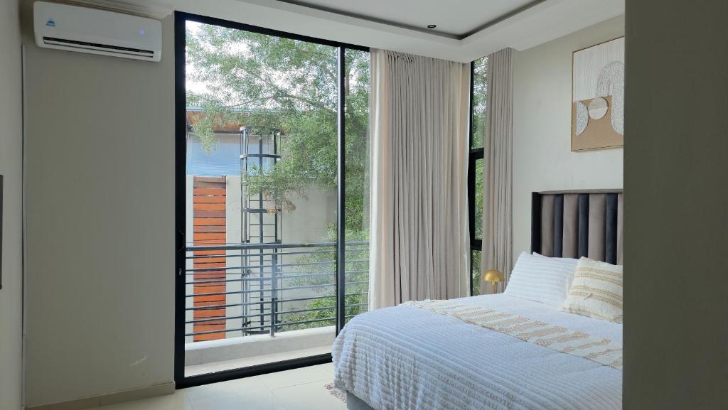 a bedroom with a bed and a large window at VnA Executive Suites in Pretoria
