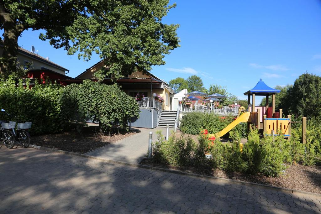 um parque infantil com um escorrega num quintal em Hotel Weserschiffchen em Porta Westfalica