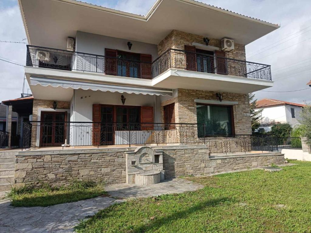 a large house with a balcony on top of it at Villa Orfani in Orfánion