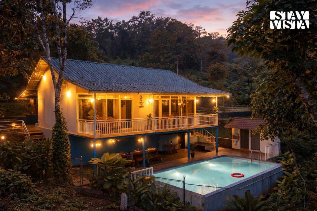 a house with a swimming pool in front of it at StayVista at Aradhya Villa with Infinity Pool, Lawn in Wayanad
