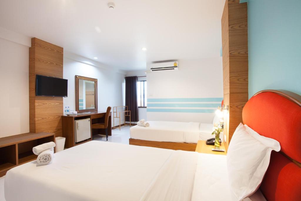 A second angle on the twin room, showing the television, desk, minibar and beds.
