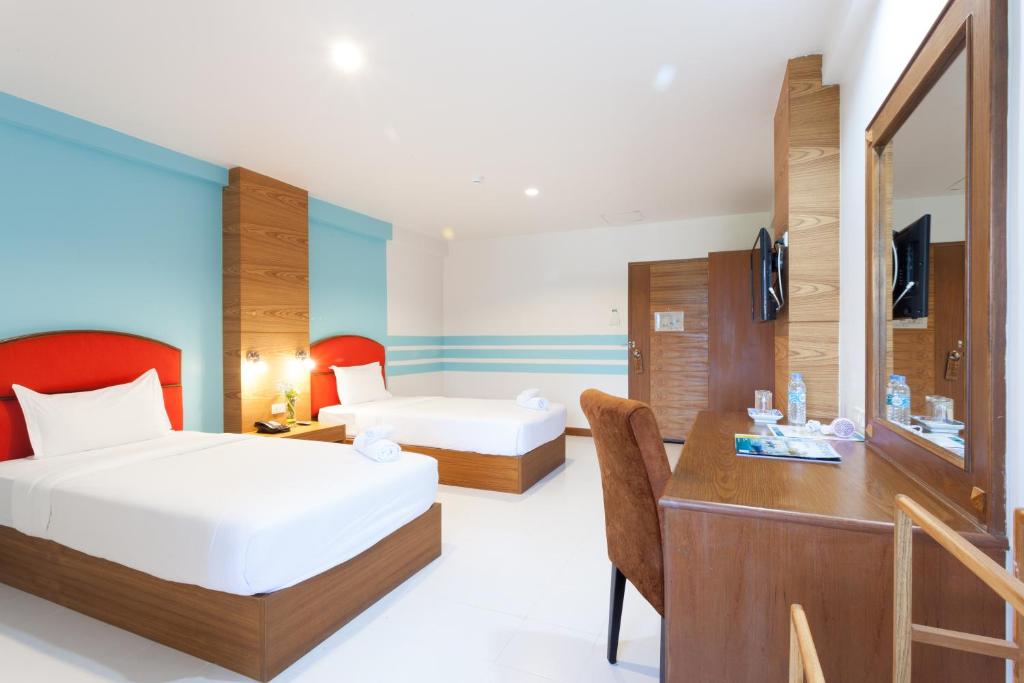 A twin room with a long dressing desk, large mirror and two separate beds.