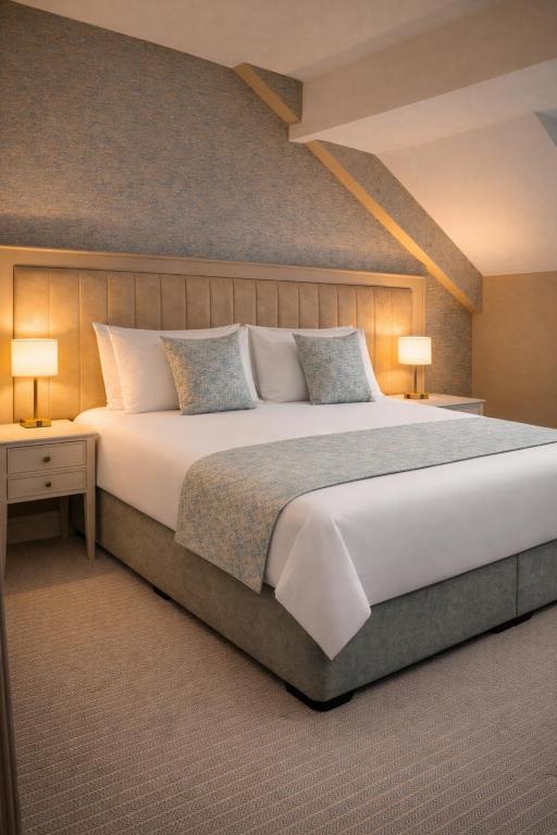 a large bed in a bedroom with two lamps at Hotel Rue in Omagh