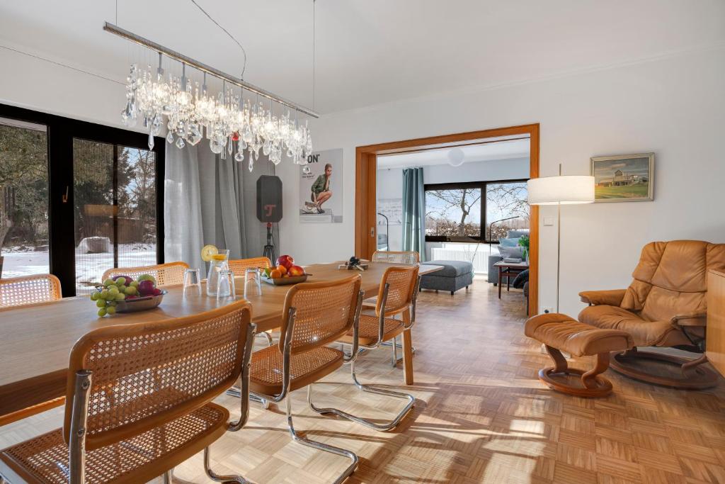 a dining room and living room with a table and chairs at Stilvoller Bauhaus Bungalow mit Sauna in Lüneburger Heide für 8 Gäste in Wohlendorf