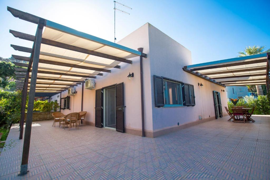 a house with a patio with tables and chairs at Villa Di Franco in Cefalù