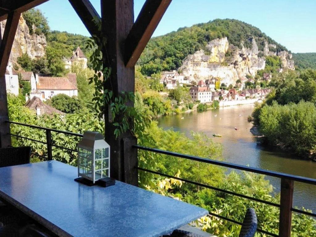 a table on a balcony with a view of a river at La Terrasse sur La Roque-Gageac in Vézac