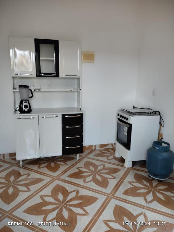 a kitchen with a counter and a stove in a room at Kitinet in Marataizes