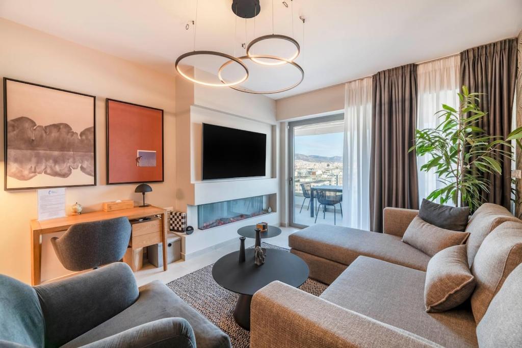a living room with a couch and a tv at The HostMaster 910 Loft in Piraeus