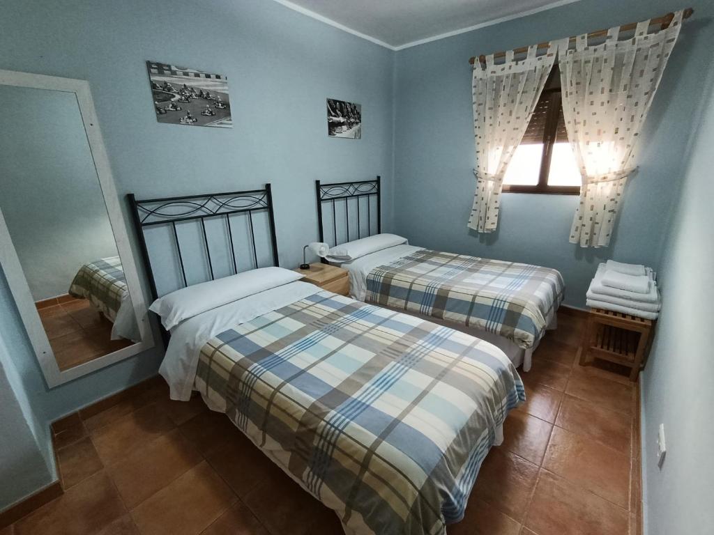 two beds in a room with blue walls at Casa Rural Javier in Valmuel