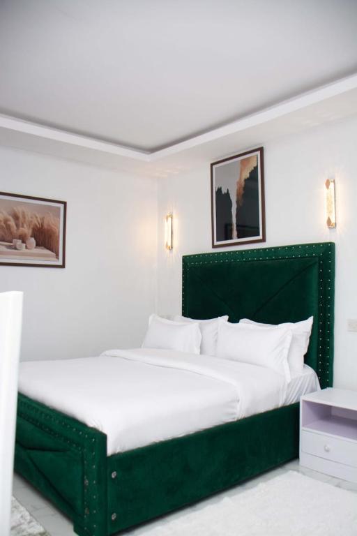 a large green bed in a white bedroom at Shanny's Cozy Studio in Eldoret