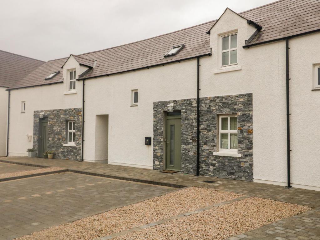 a row of white brick houses with a driveway at Portnablagh Cottage in Dunfanaghy