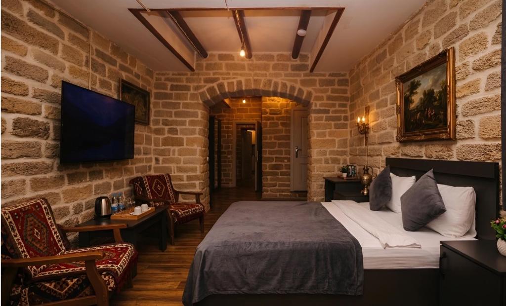 a hotel room with a bed and two chairs at Green Garden Hotel in Baku