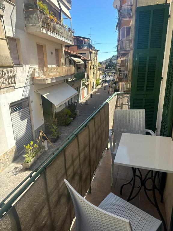 a balcony with a table and chairs on a city street at Appartamento Centrale - sulla pedonale in Dolceacqua