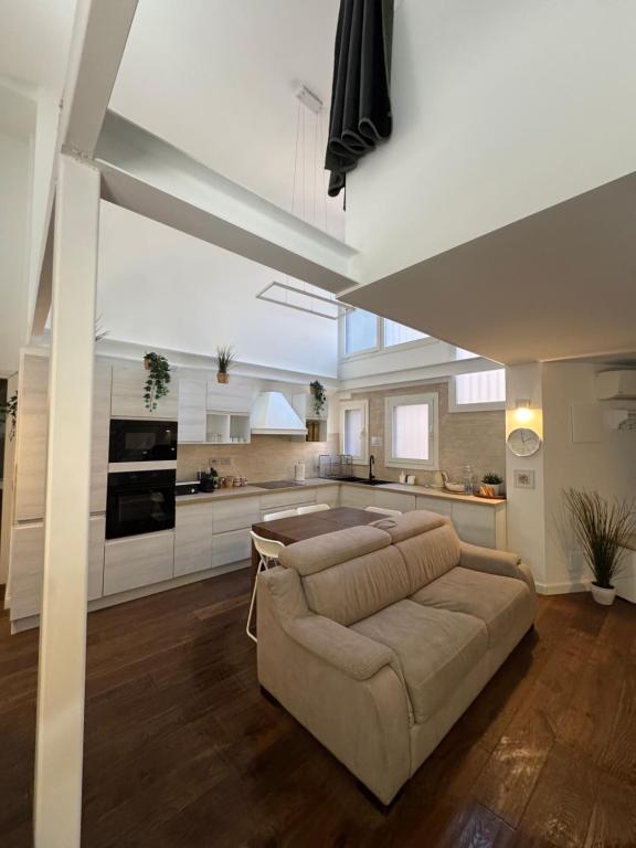 a living room with a couch and a kitchen at DEA DREAMS - Lofty Marghera in Milan