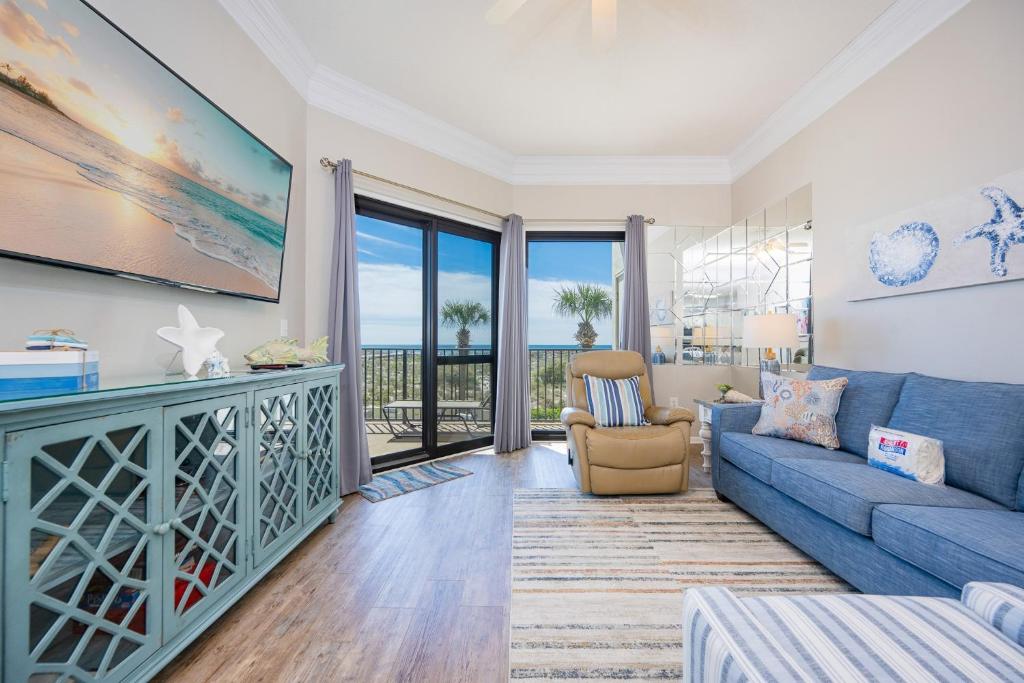 a living room with a blue couch and views of the ocean at Phoenix VI 6104 in Orange Beach