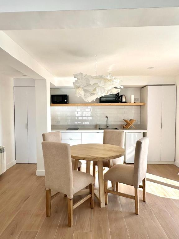 a kitchen and dining room with a wooden table and chairs at Apart Exclusivo a Estrenar - Tu Base Perfecta in El Calafate