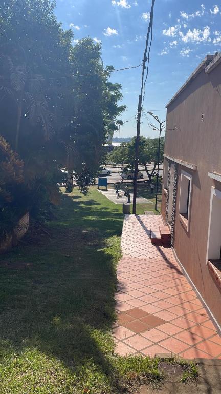 a brick walkway next to a building next to a park at Roberto in Posadas