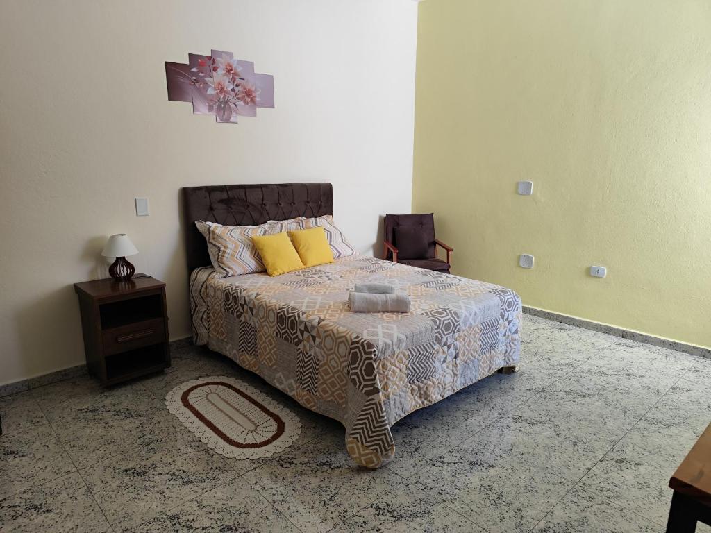 a bedroom with a bed and a table and a chair at Soninho Bão in Cunha
