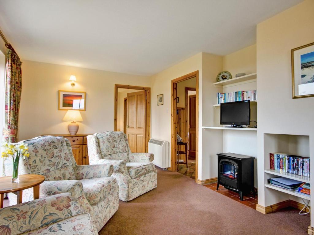 a living room with two chairs and a fireplace at Moy in Taynish